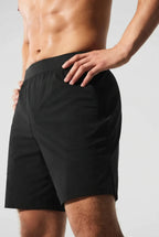 Close-up side view of a man wearing black active shorts with an elastic waistband and side pocket