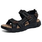Angled view of black leather sandal with triple hook-and-loop straps, mesh side panels and chunky black cushioned outsole