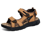 Three-quarter view of light brown leather sandal with adjustable straps, mesh ventilation cutouts and patterned cushioned insole