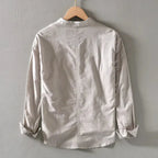 Beige linen shirt on wooden hanger, back view showing centre seam and relaxed shoulders