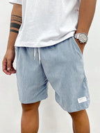 Side view of teal blue corduroy shorts showing relaxed leg fit and texture