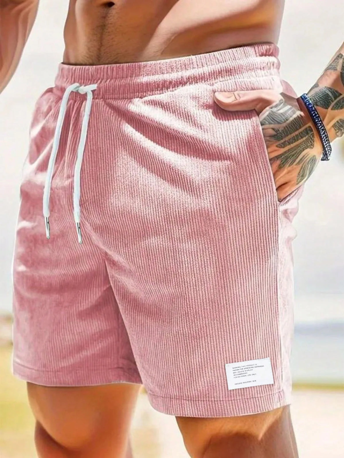 Close-up of sage green corduroy shorts fabric texture and fabric label near hem