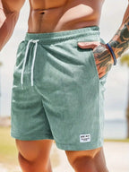 Close-up of black corduroy shorts pocket and drawstring against outdoor beach setting