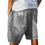Back view of grey corduroy shorts with patch pocket and side pocket, worn with a white t-shirt