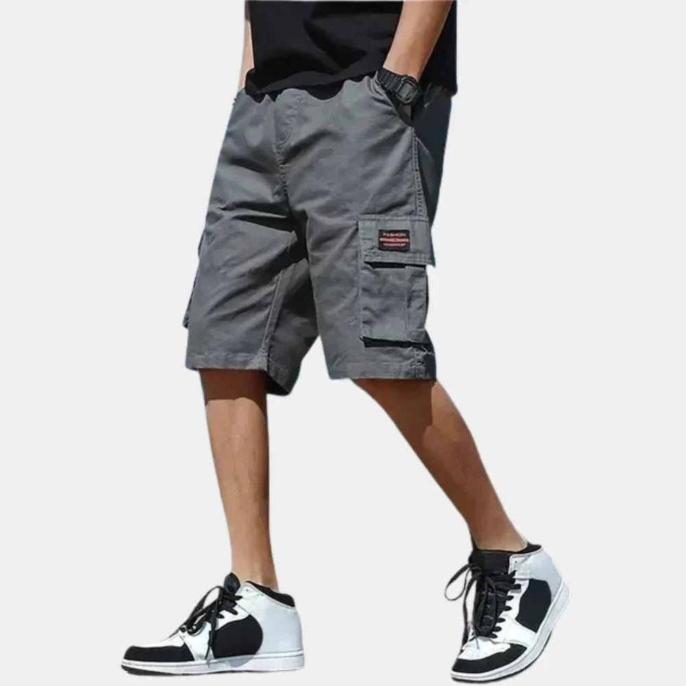 Grey cargo shorts worn with a white t-shirt, showing double side pockets and relaxed loose-fit silhouette