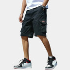 Black cargo shorts paired with a white t-shirt, highlighting the flap pocket and straight hem just above the knee