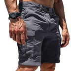 Close-up side view of grey cotton cargo shorts with a large flap pocket and visible belt loops, worn with a wristwatch