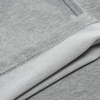 Close-up of the fabric hem and stitching detail showing the soft cotton-blend texture of the grey joggers.