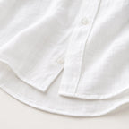 Close-up of the white shirt's curved hem and side button placket detailing