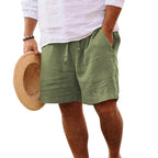 Side view of a man wearing khaki green drawstring shorts with hand in pocket, cropped below the waist