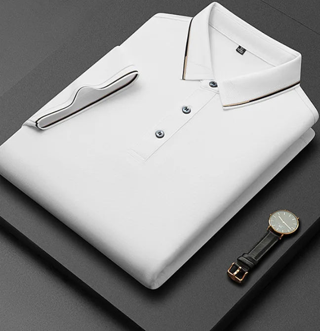 Folded white polo shirt with striped collar trim, displayed next to a leather strap watch