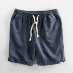 Navy blue linen-look shorts flat lay showing elastic waistband and cream drawstring cord