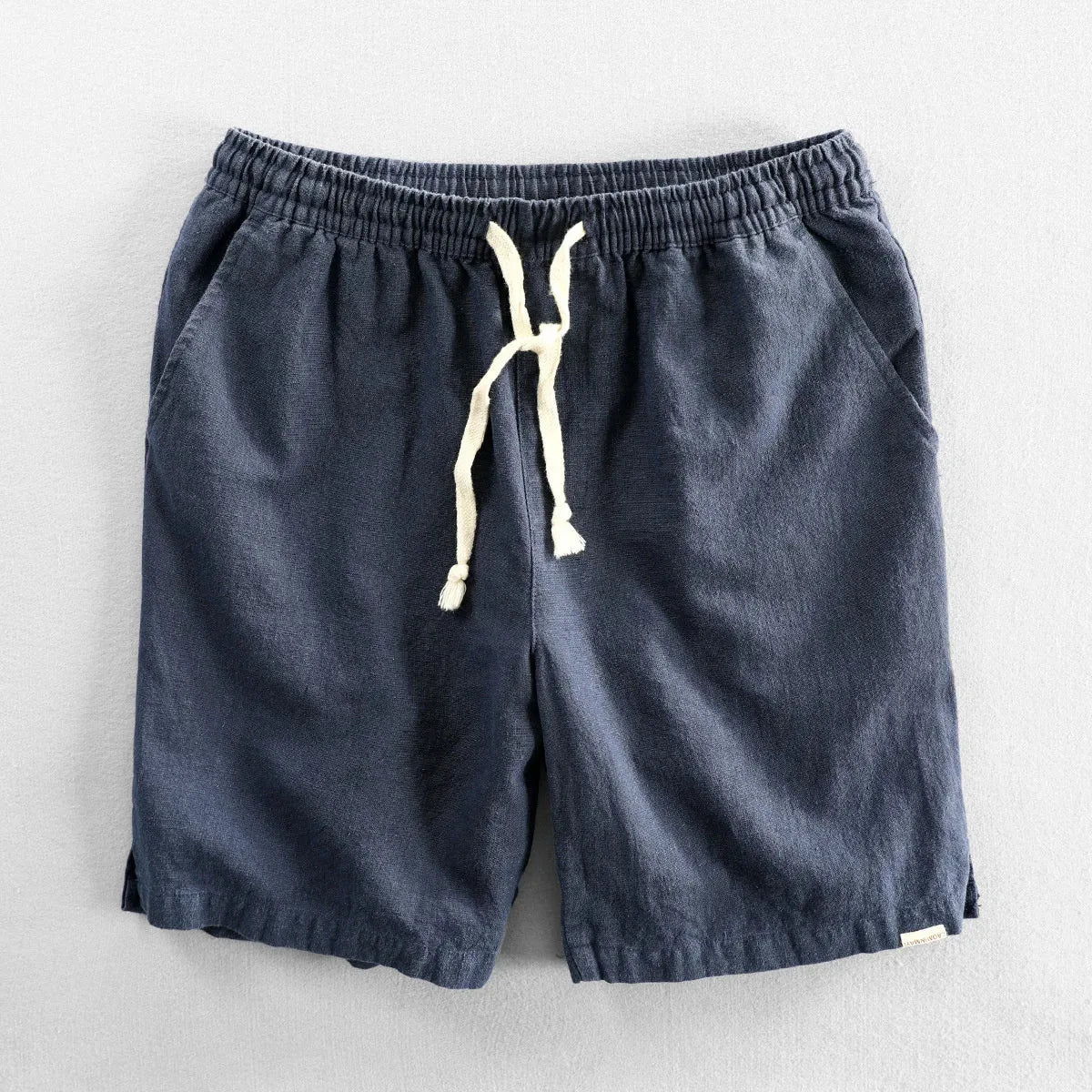 Navy blue linen-look shorts flat lay showing elastic waistband and cream drawstring cord