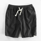 Black drawstring shorts flat lay highlighting the relaxed fit and natural fabric texture