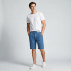Model wearing steel blue drawstring shorts with a white t-shirt and white sneakers, front angle