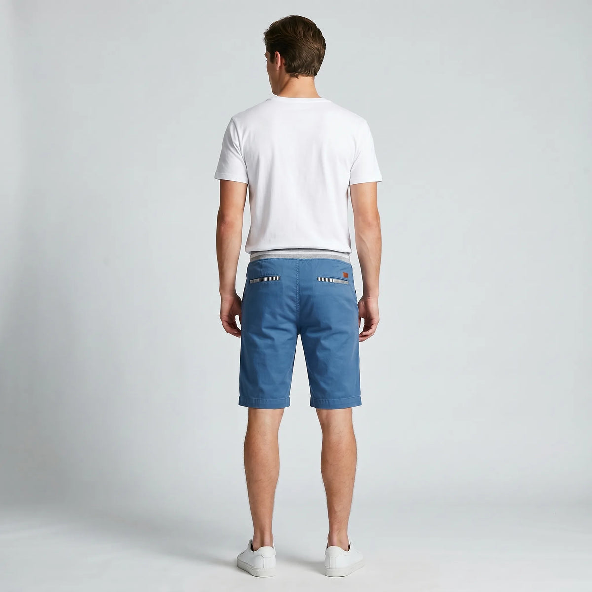 Back view of steel blue shorts showing welt pockets with striped trim and relaxed fit