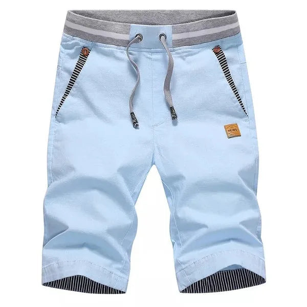 Flat lay of knee-length drawstring shorts in pale sky blue with striped pocket trim