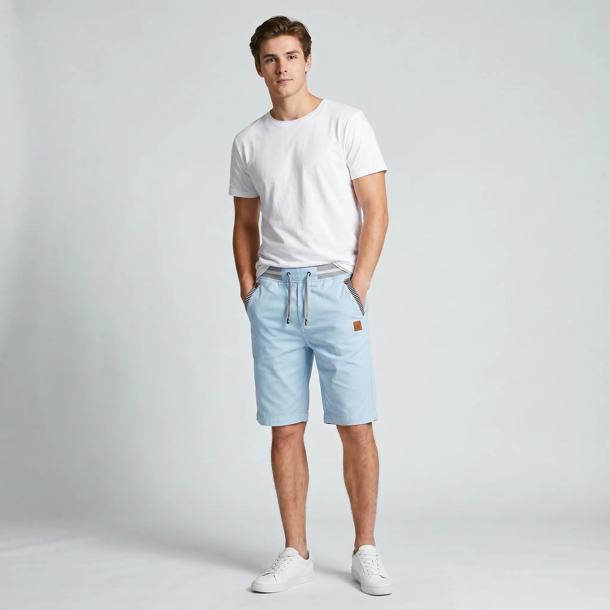 Model standing in sky blue knee-length shorts, front angle showing relaxed silhouette