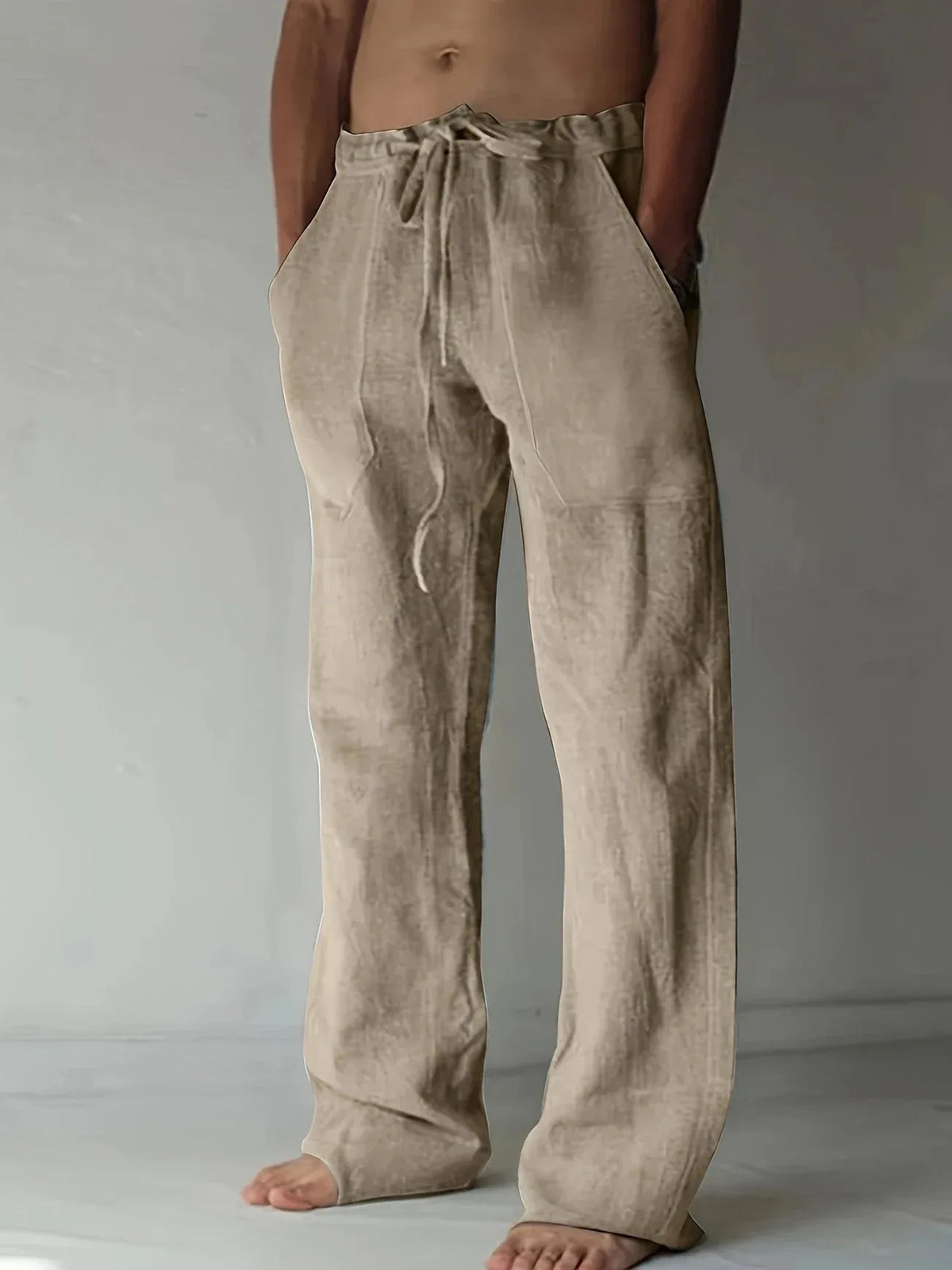 Light taupe linen drawstring pants with wide straight legs and a visible drawstring waist detail