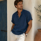 Side-angled view of a man wearing the navy linen shirt, showing the relaxed fit and rolled sleeve detail