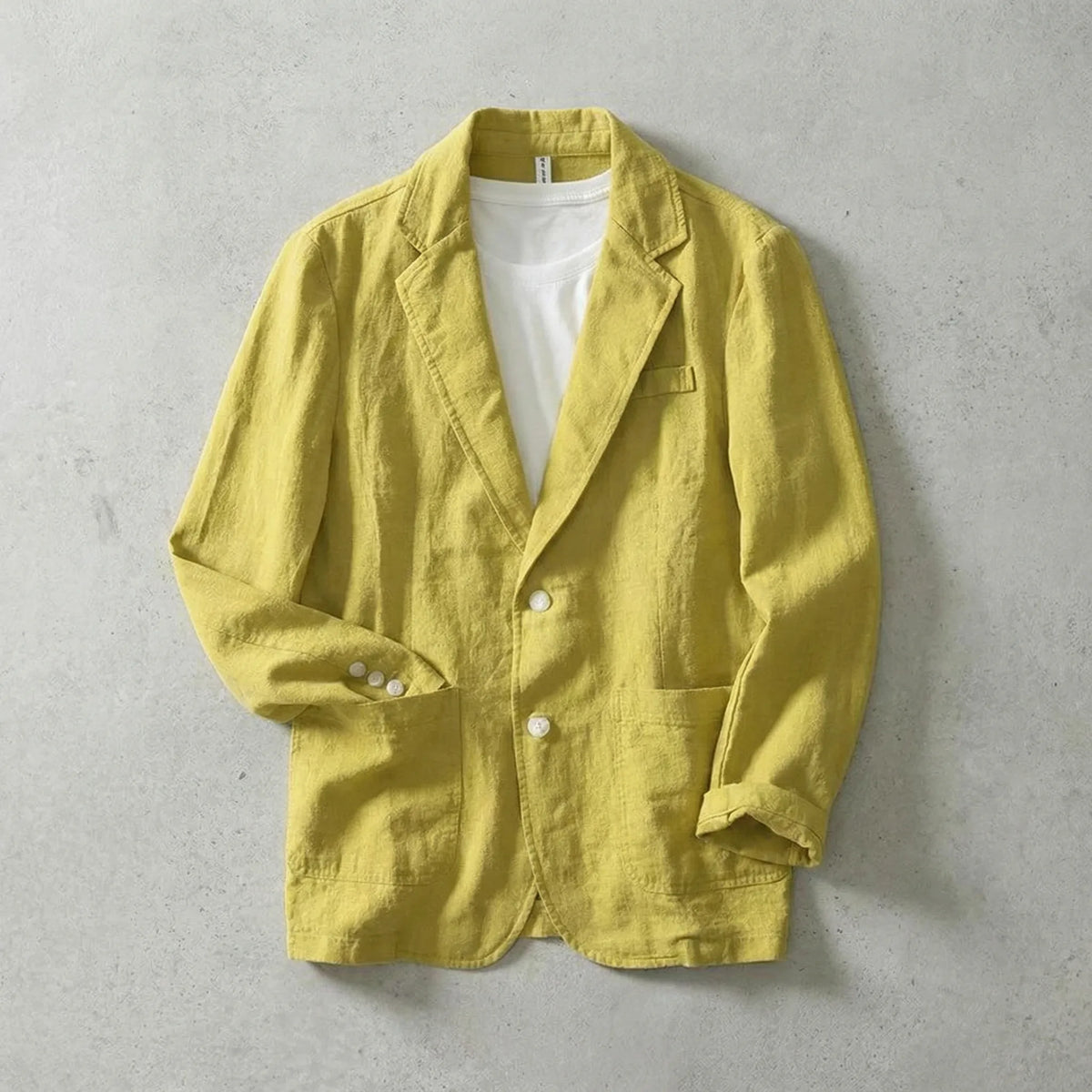 Yellow linen blazer buttoned up with rolled sleeves, showing white button detail and front patch pockets