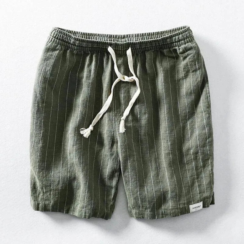 Flat lay of green pinstripe linen-blend shorts with elastic drawstring waist on a grey background