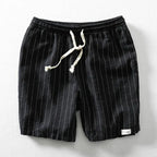 Black pinstripe linen-blend shorts with white drawstring cord, flat lay view