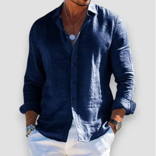 Navy blue linen-blend shirt with open collar and rolled sleeves, styled with white trousers