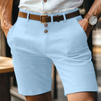 Pale blue linen-blend shorts with button fastening, styled with white shirt and brown leather belt