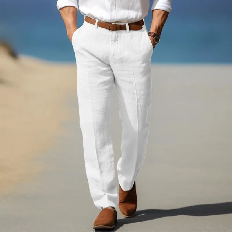 Rear view of man walking on a beach boardwalk in crisp white linen trousers with tan ankle boots