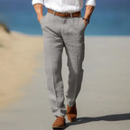 Close-up rear view of man walking in light grey linen trousers with a leather belt