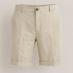 Flat lay of beige linen shorts with button fly, belt loops and side pockets on a neutral background