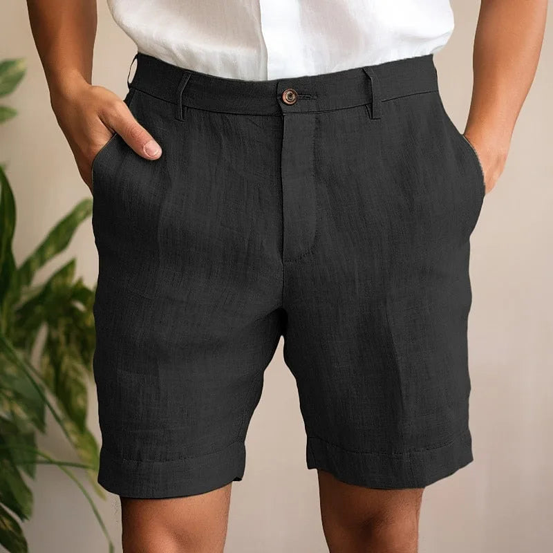 Close-up of black linen shorts highlighting the textured weave, belt loops and turn-up cuffs