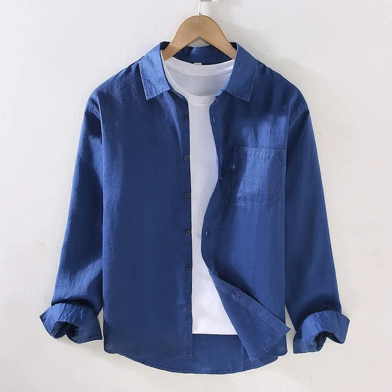 Blue linen shirt on a hanger, full front view with rolled sleeves and relaxed drape over a white tee