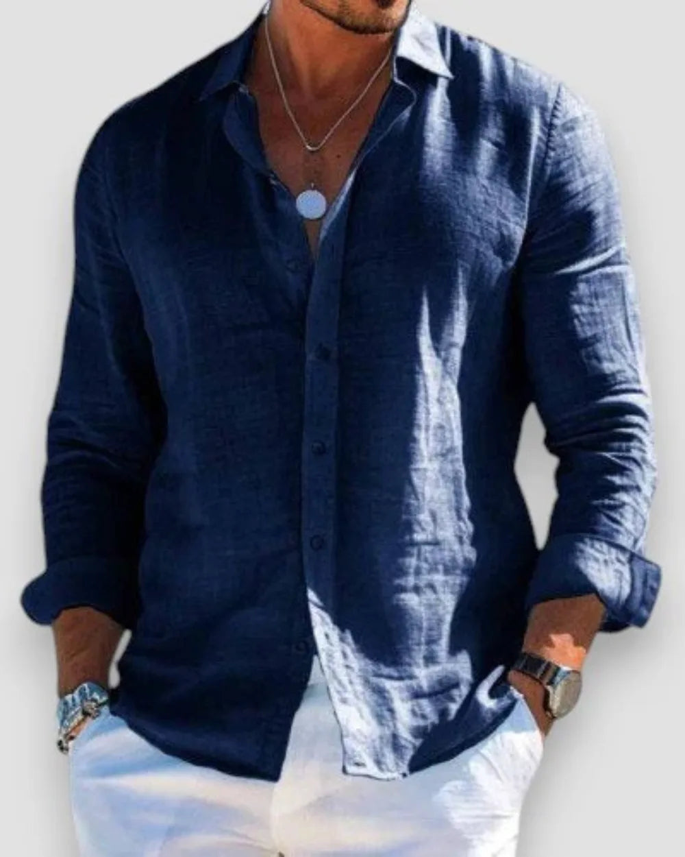 Navy linen shirt with collar and long sleeves rolled to the forearm, worn with white trousers