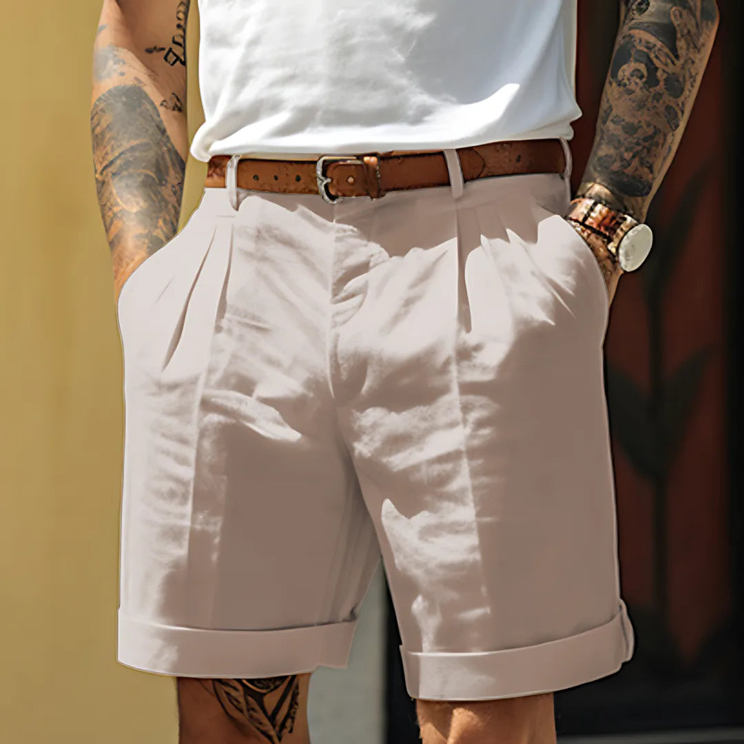 Light grey tailored shorts with pleated front and cuffed hem, paired with a tan leather belt