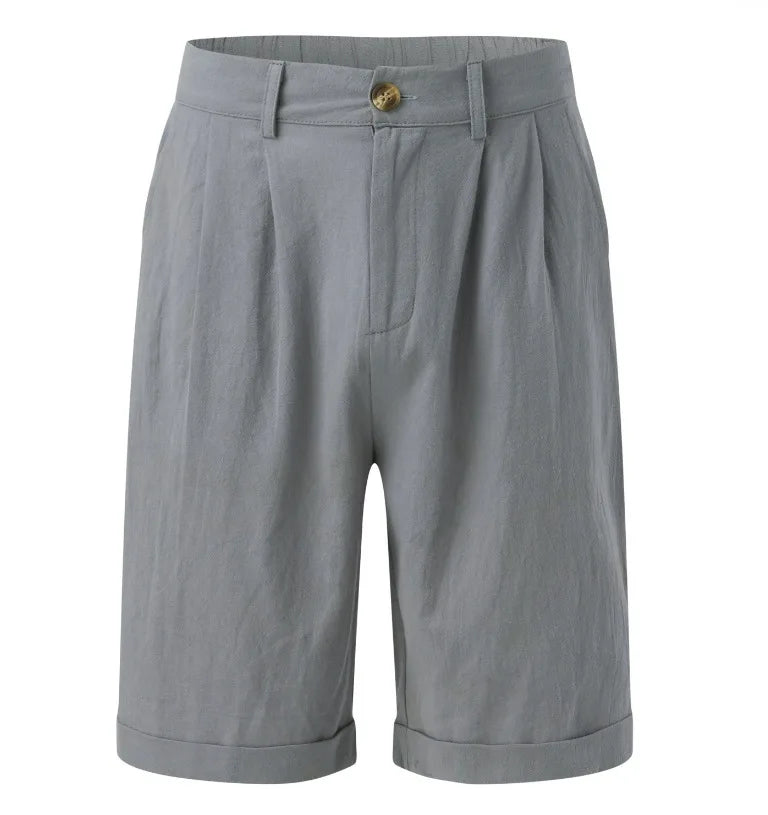 Flat lay of grey tailored shorts showing button fastening, belt loops, pleats and cuffed hem