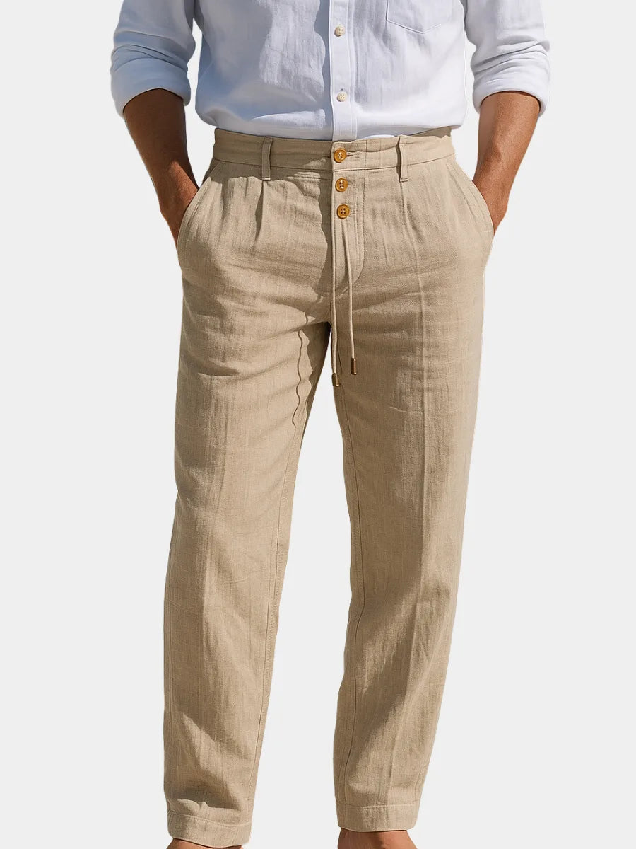 Front view of man wearing khaki-beige linen trousers with tie waist and three-button fly, paired with a white linen shirt