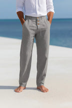 Grey linen trousers shown from the front, highlighting the loose straight cut and natural fabric texture