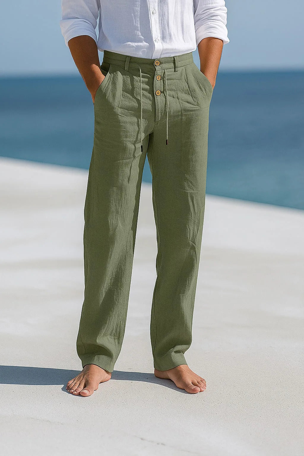 Olive green linen trousers worn with hands in pockets, showing the relaxed fit from waist to ankle