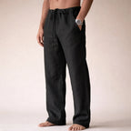 Side view of black linen pants showing drawstring waistband and slim straight silhouette