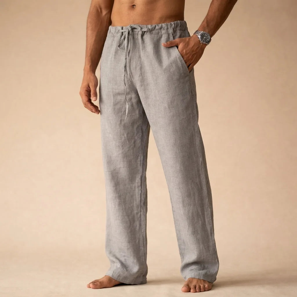 Close front view of grey linen trousers with drawstring tie and hand in side pocket
