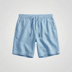 Light blue linen shorts shown flat, featuring an elasticated drawstring waist and side pockets