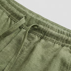 Close-up of the waistband and fly detail on navy blue linen shorts
