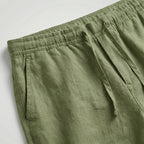 Black linen shorts laid flat, showing the elasticated waist and drawstring