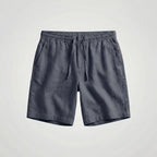Close-up of the stitched pocket opening on black linen shorts
