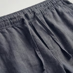 Green linen shorts laid flat, highlighting the relaxed above-knee length
