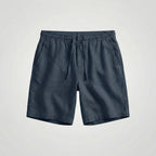 Close-up of the woven linen fabric texture on green shorts