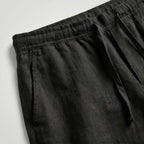 Grey linen shorts shown from a slight angle, highlighting the fabric drape