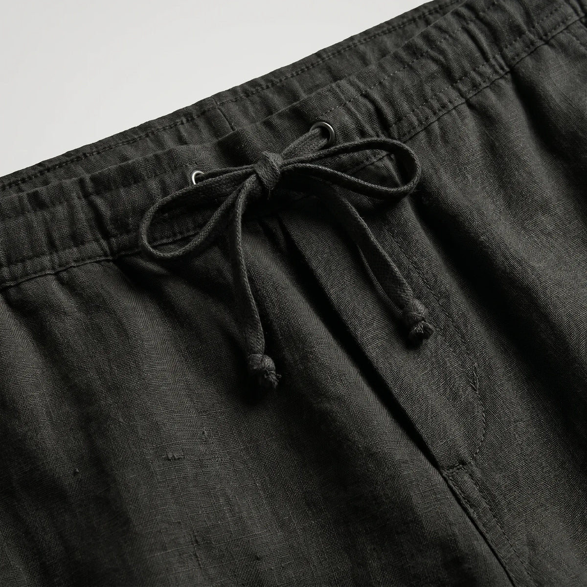 Khaki linen shorts shown from above, displaying the full silhouette and leg openings
